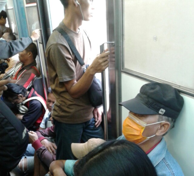 Penumpang duduk di lantai Commuter Line